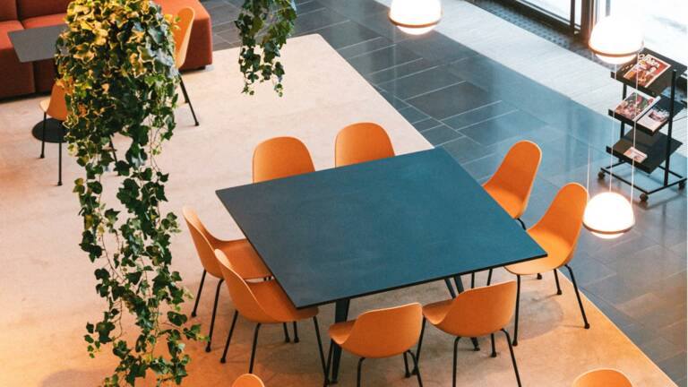 Toimitilakiinteistön aulassa olevan kahvion pöytä ja tuolit.